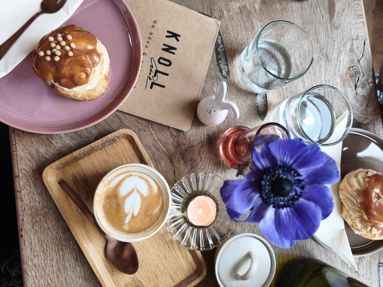 Kapučíno a větrník na stole v kavárně v Lednici, pohled shora na kávu a dezert Kapučíno a větrník na stole v kavárně v Lednici, pohled shora na kávu a dezert