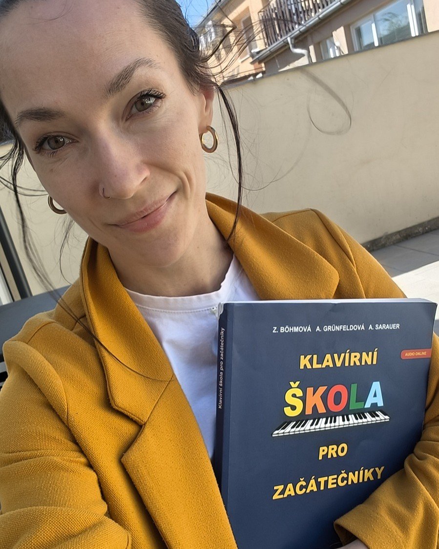 Žena drží učebnici klavíru pro začátečníky po první lekci hry na piano