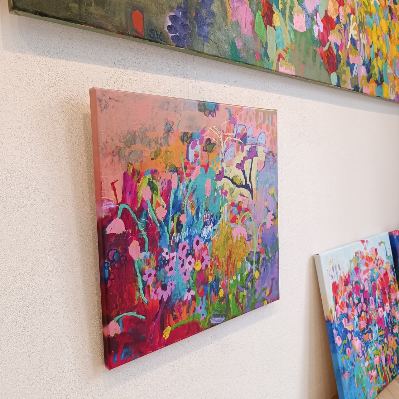 Menší reprodukce abstraktního květinového obrazu na plátně zavěšená na zdi, barevná dekorace do obývacího pokoje