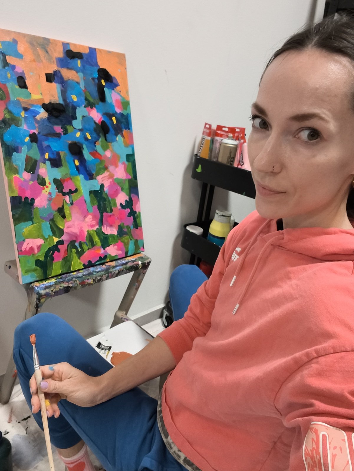 Malba menšího abstraktního obrazu s motivem kosatců