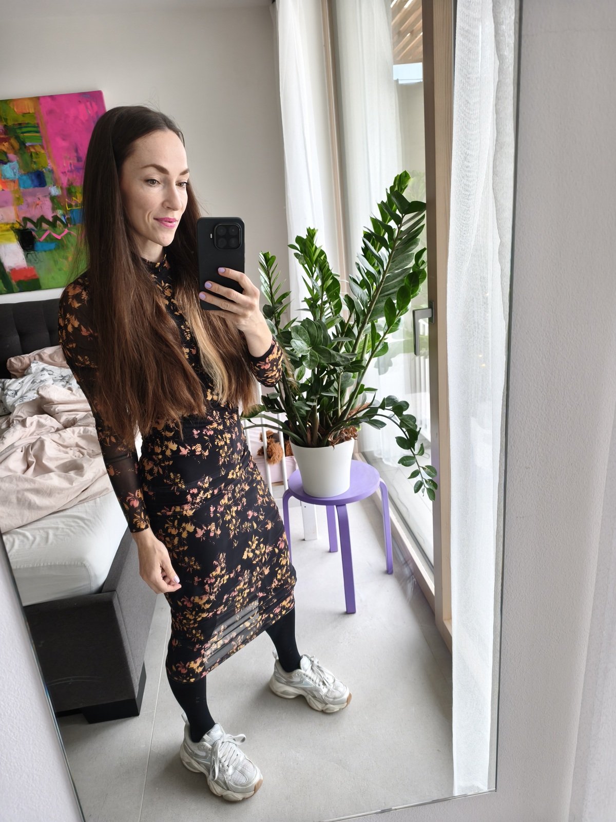 Selfie před setkáním absolventů v ložnici s abstraktním obrazem