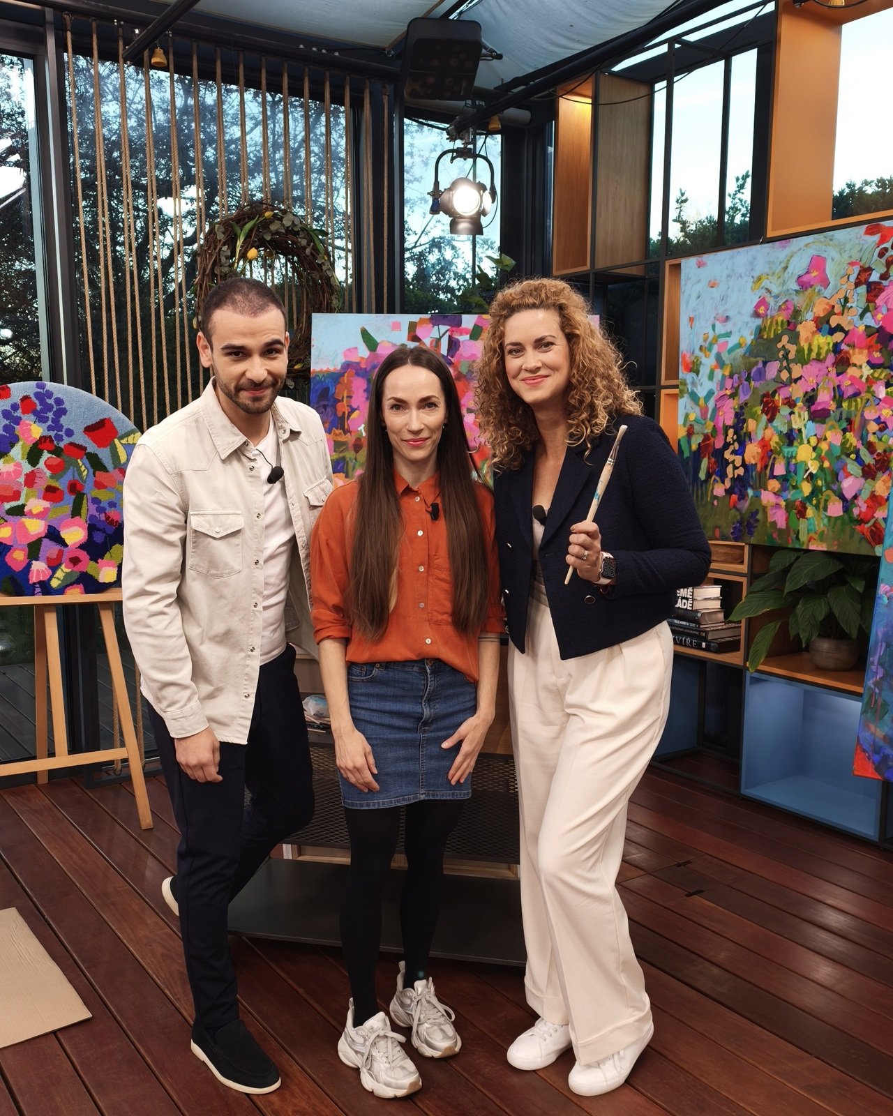 Simona Vojtěšková s moderátory Kateřinou Pechovou a Dominikem Vršianským u květinových obrazů